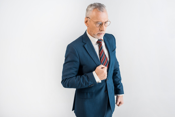 overhead view of mature man in suit and glasses standing isolated on grey  - 写真・画像