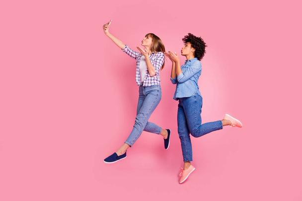 Full length body size profile side view of two person nice lovely attractive charming cheerful playful flirty girls having fun time taking making selfie isolated over pink pastel background - Foto, Bild