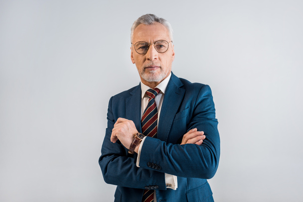 maturo uomo d'affari in giacca e cravatta con braccia incrociate isolato su grigio
  - Foto, immagini