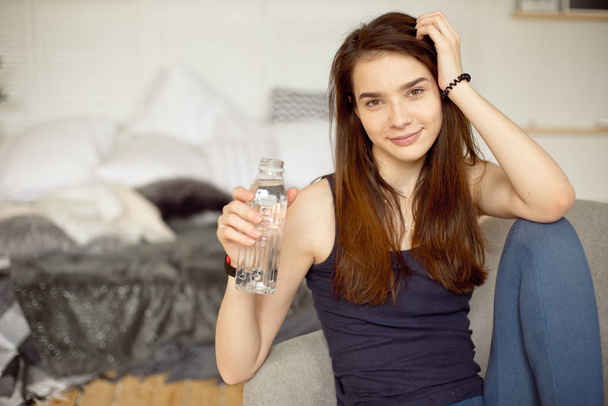 Sports girl with dark hair holding bottle of clear water healthy food, healthy lifestyle - Φωτογραφία, εικόνα