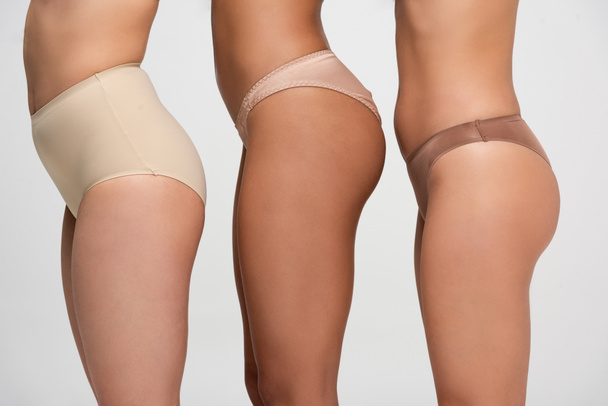 cropped view of three multiethnic woman in panties isolated on grey, body positivity concept - Photo, Image