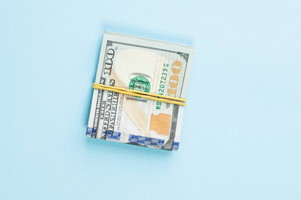 100 долларов США наличными на синем фоне стола
 - Фото, изображение