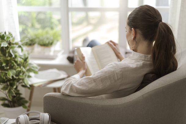 Woman relaxing and reading a book - Foto, Bild