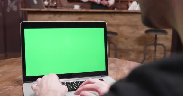 緑の画面のコンピューターで作業する人のハンドヘルド ショット - 映像、動画