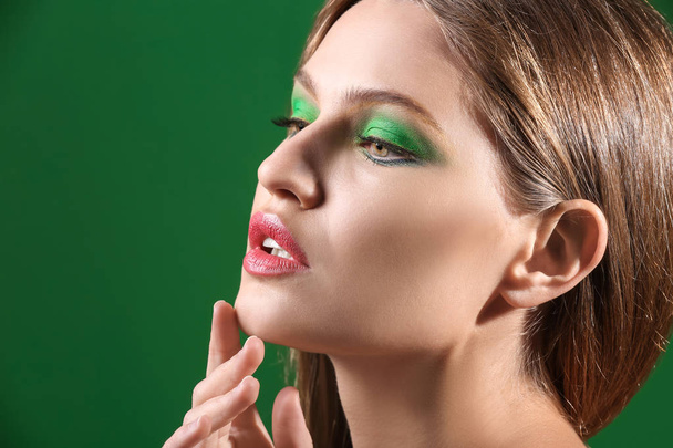 Beautiful young woman with bright makeup on color background - Φωτογραφία, εικόνα
