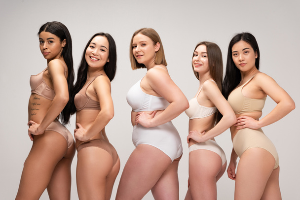 five pretty multiethnic girls in lingerie posing at camera with hands on hips isolated on grey, body positivity concept - Fotoğraf, Görsel