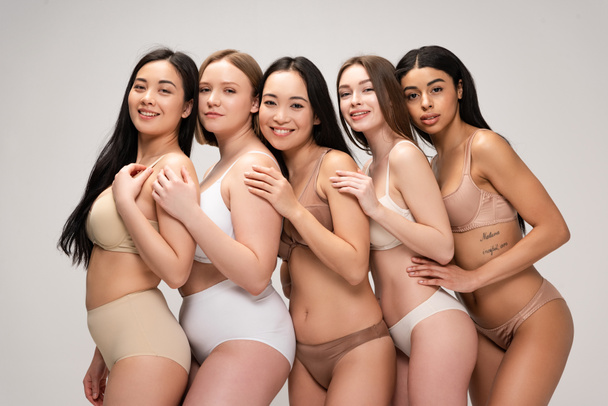 five happy young woman embracing each other and smiling isolated on grey, body positivity concept - Φωτογραφία, εικόνα