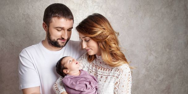 Woman and man holding a newborn. Mom, dad and baby.  Portrait of - Фото, зображення