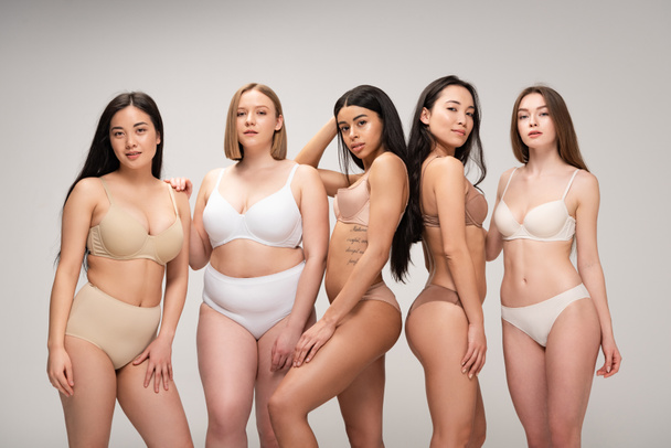 five smiling multiethnic girls smiling and posing at camera isolated on grey, body positivity concept  - Фото, изображение
