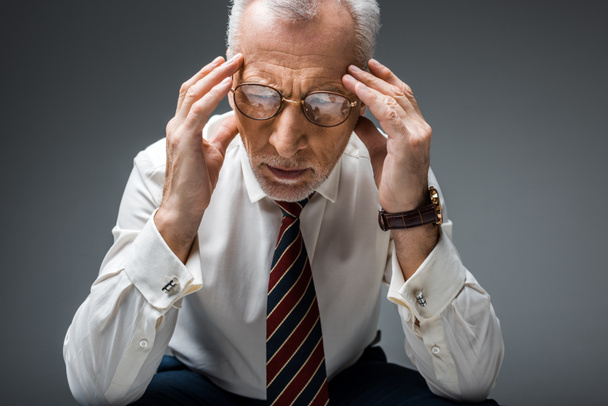 tired middle aged businessman in formal wear having headache on grey  - Фото, изображение