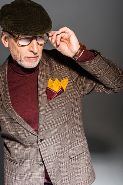 trendiger Mann mittleren Alters mit Brille auf grau - Foto, Bild