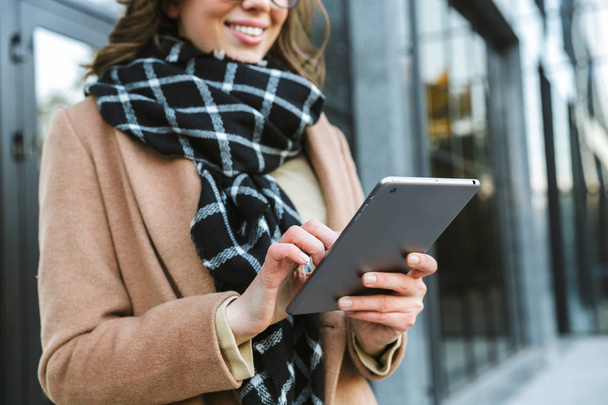 Woman outdoors walking by street using tablet computer. - Photo, image