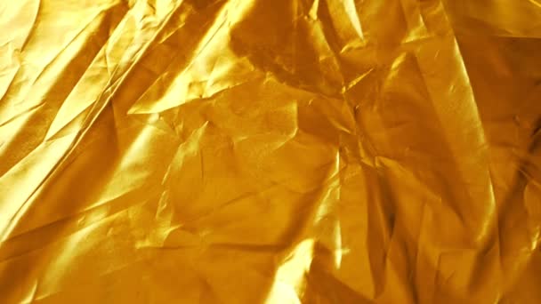 Background of golden synthetic crumpled fabric. close-up. fabric texture. light-reflecting fabric - Footage, Video