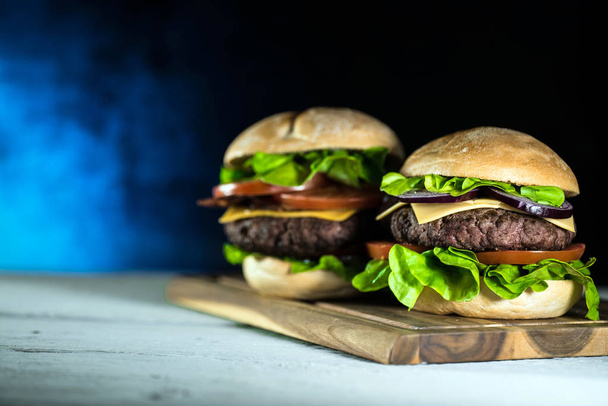 due gustosi cheeseburger freschi su tavola di legno, concetto di fast food
  - Foto, immagini