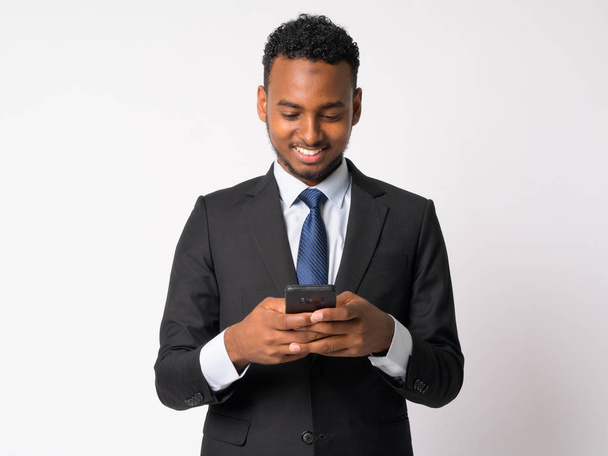 Χαρούμενος νεαρός όμορφος αφρικανική επιχειρηματίας χρησιμοποιώντας το τηλέφωνό - Φωτογραφία, εικόνα