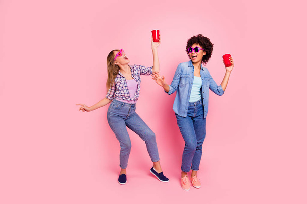 Full length body size view portrait of two person nice attractive cheerful cheery girls in casual checkered shirt dancing having fun isolated over pink pastel background - Zdjęcie, obraz