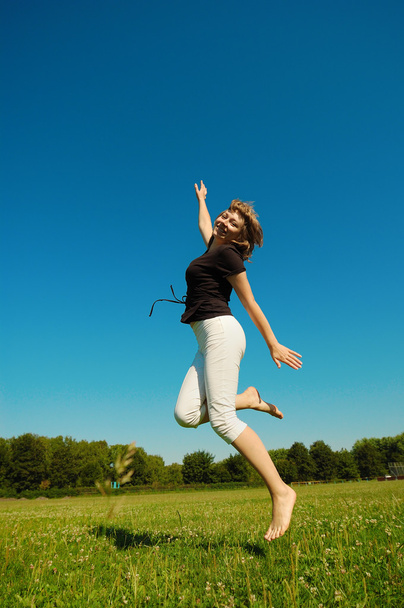 Jumping girl against blue sky - Photo, Image