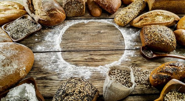 Vielzahl köstlicher Brotlaibe auf hölzernem Hintergrund  - Foto, Bild