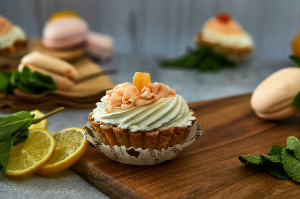 Cake basket with cream and lemon on a wooden board.  - Photo, Image