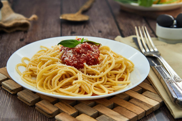 Вкусные красочные закуски приготовленные спагетти итальянская паста с томатным соусом болоньезе и свежий базилик
.  - Фото, изображение