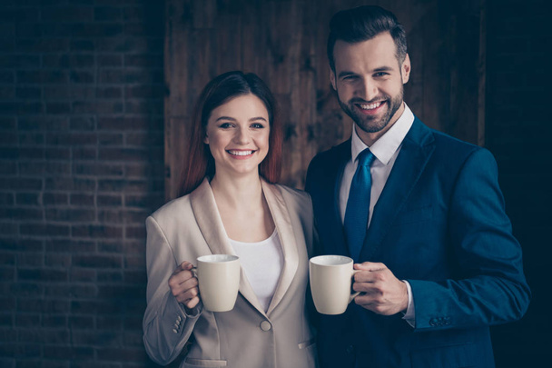 Close up photo she her business lady he him his guy partners friends buddies hold hot beverage hands arms look camera leisure rejoice morning tea coffee stand office wearing formal wear suits - Fotografie, Obrázek
