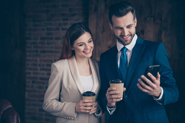 Close up photo she her business lady he him his guy buddies hold hot beverage hands arms look smart phone pictures leisure rejoice morning tea coffee stand office wearing formal wear suits - Foto, Bild