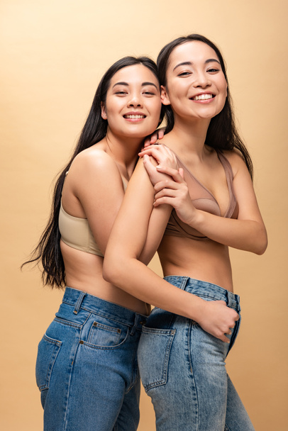 two cheerful multicultural girls hugging and looking at camera isolated on beige, body positivity concept - Фото, зображення