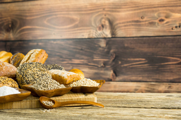 variety of delicious loaves of bread on wooden background  - Foto, afbeelding