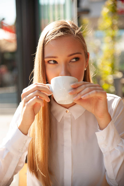 Business woman has a coffee break and drinks coffee in a bar - Фото, зображення