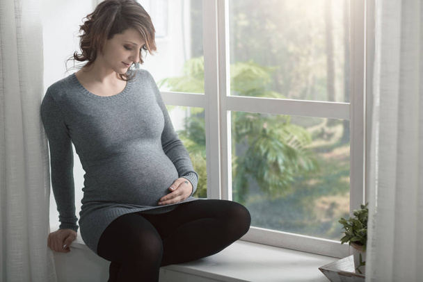 Young pregnant woman relaxing at home - Fotoğraf, Görsel