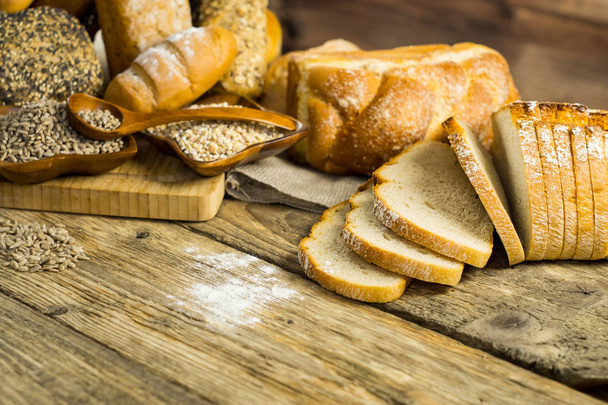 variety of delicious loaves of bread on wooden table  - Valokuva, kuva