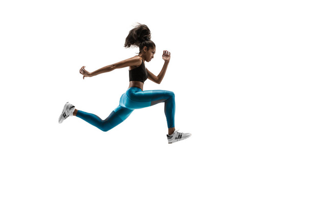 Young african woman running or jogging isolated on white studio background. - Фото, зображення