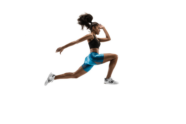 Young african woman running or jogging isolated on white studio background. - Foto, imagen