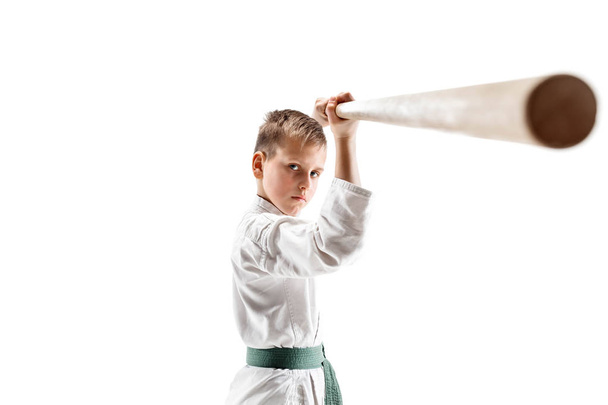 Teen boy fighting with wooden sword at Aikido training in martial arts school - Fotó, kép