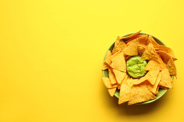 Plate with tasty nachos and guacamole on color background - Fotoğraf, Görsel