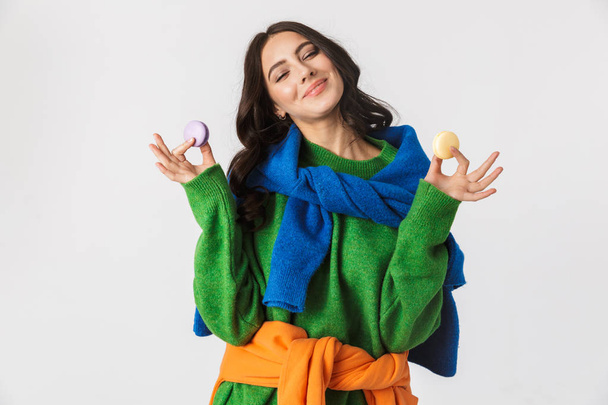 Portrait of joyous woman 30s in colorful clothes holding macaron - Фото, зображення