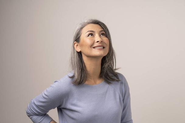 Charming Asian woman is smiling on white background - Valokuva, kuva