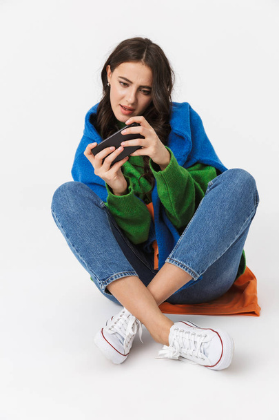 Image of cheerful woman 30s in colorful clothes sitting on the f - Foto, imagen