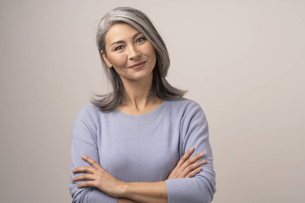 Beautiful Mongolian Woman with Gray Hair on a White Background. - Foto, afbeelding