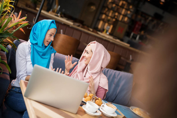 Muslimische Frauen arbeiten im Café und benutzen Computer - Foto, Bild