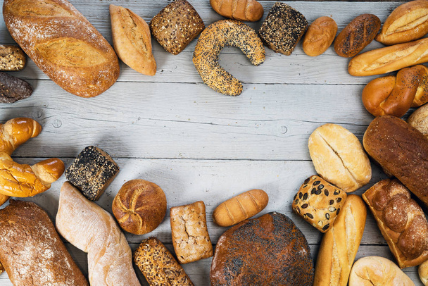 variety of delicious loaves of bread on wooden table  - Photo, Image
