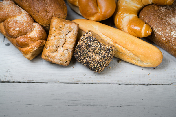variedad de deliciosos panes sobre mesa de madera
  - Foto, Imagen