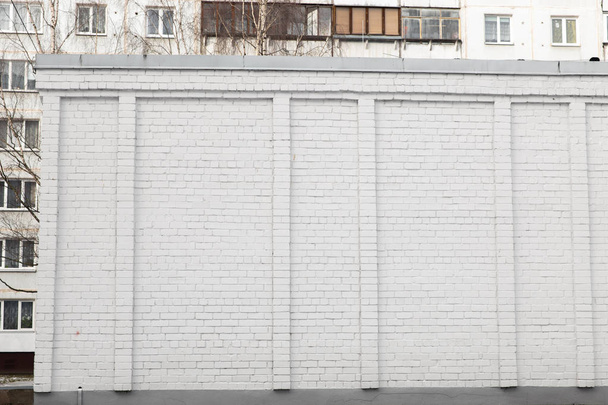 Blank ad space on a white brick wall in the street outside - Foto, afbeelding