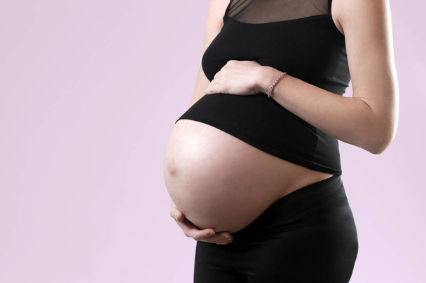 Těhotná žena drží její břicho - studio zastřelil - Fotografie, Obrázek