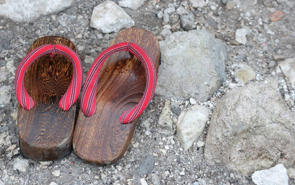 Japońskie buty Geta na kamiennym podłożu. - Zdjęcie, obraz