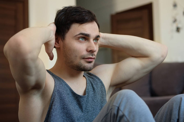 Handsome man doing abdominal exercises at home - Valokuva, kuva