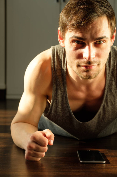 Portrait of a handsome man doing exercises at home - Фото, изображение