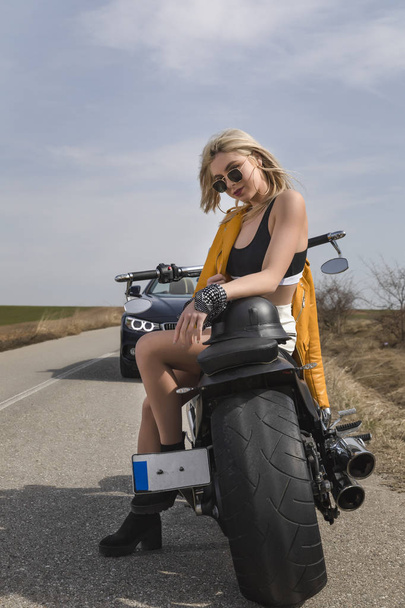 Kaunis nuori nainen istuu musta ja kromi moottoripyörä
 - Valokuva, kuva