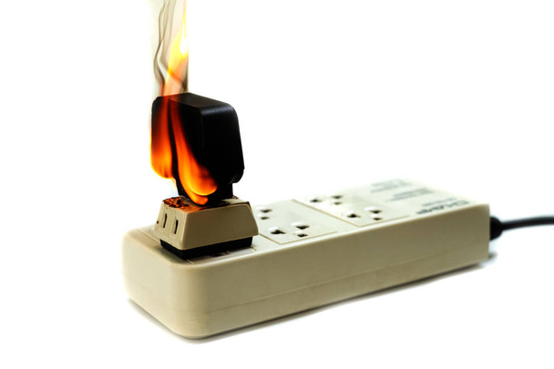 Φωτιά ηλεκτρικό καλώδιο βύσμα προσαρμογέα σε άσπρο φόντο, ηλεκτρικό βραχυκυκλώματος ανεπάρκεια που οδηγεί σε ηλεκτρική ενέργεια καλωδίων καμένο και δοχείο - Φωτογραφία, εικόνα