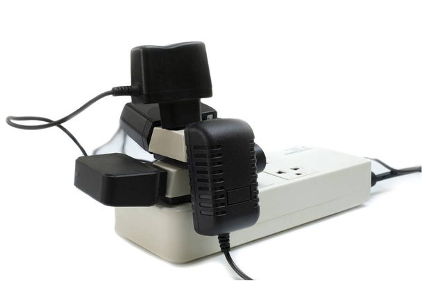 Enchufe múltiple con toma de corriente conectada con un montón de enchufes y adaptador en fondo blanco
 - Foto, imagen